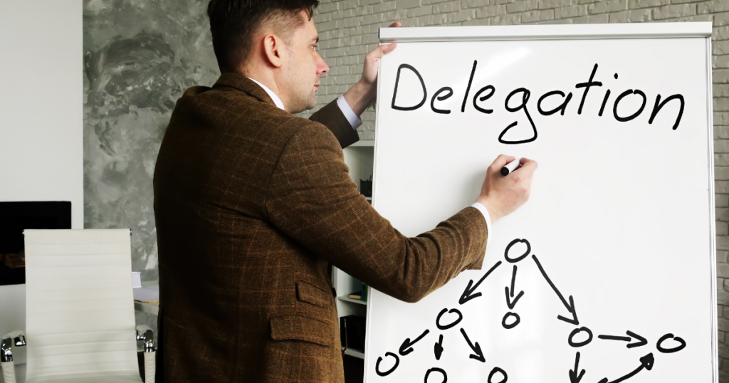 Image of man charting out his work delegation on a large white board