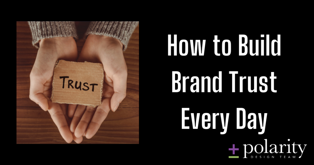 Photo of hands holding a piece of cardboard with "trust" written on it, and overlay text reading "How to Build Brand Trust Every Day"
